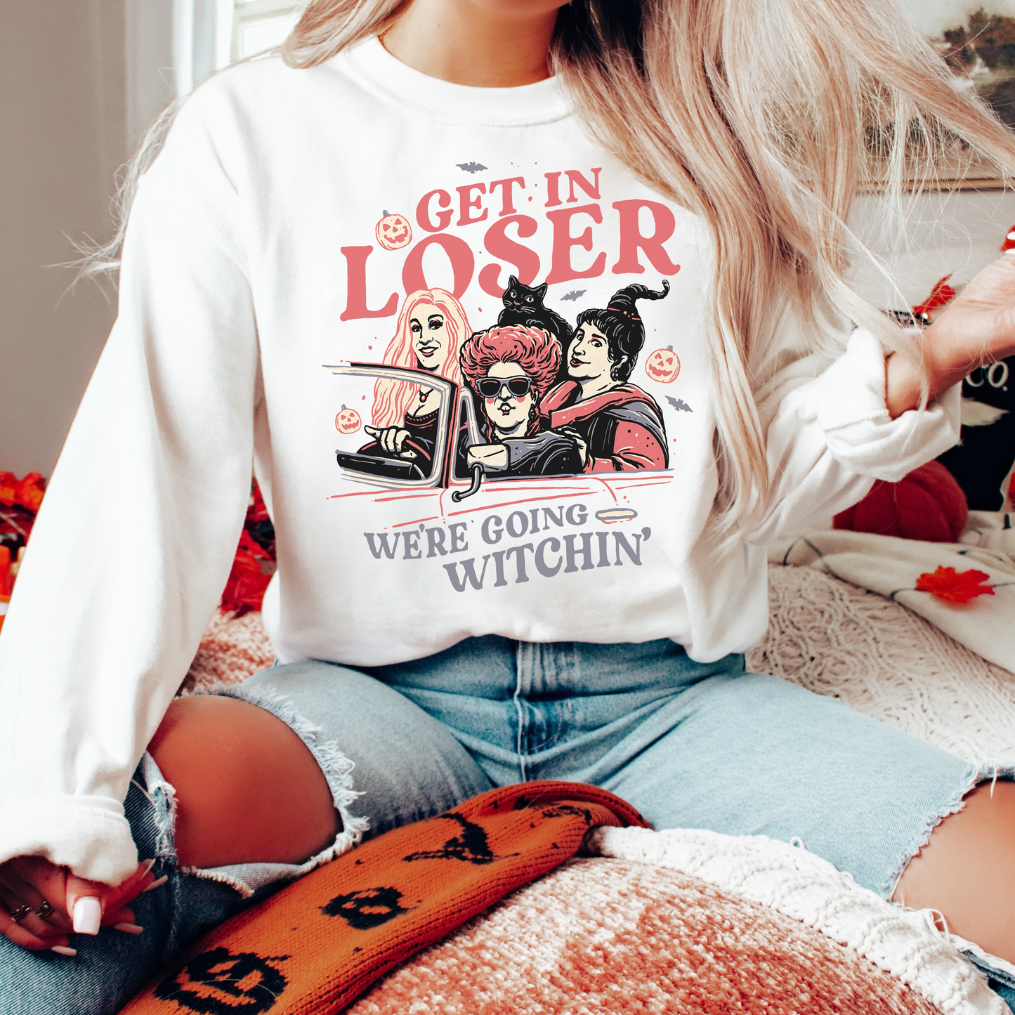 Person wearing a sweatshirt with Halloween-themed graphics and text.