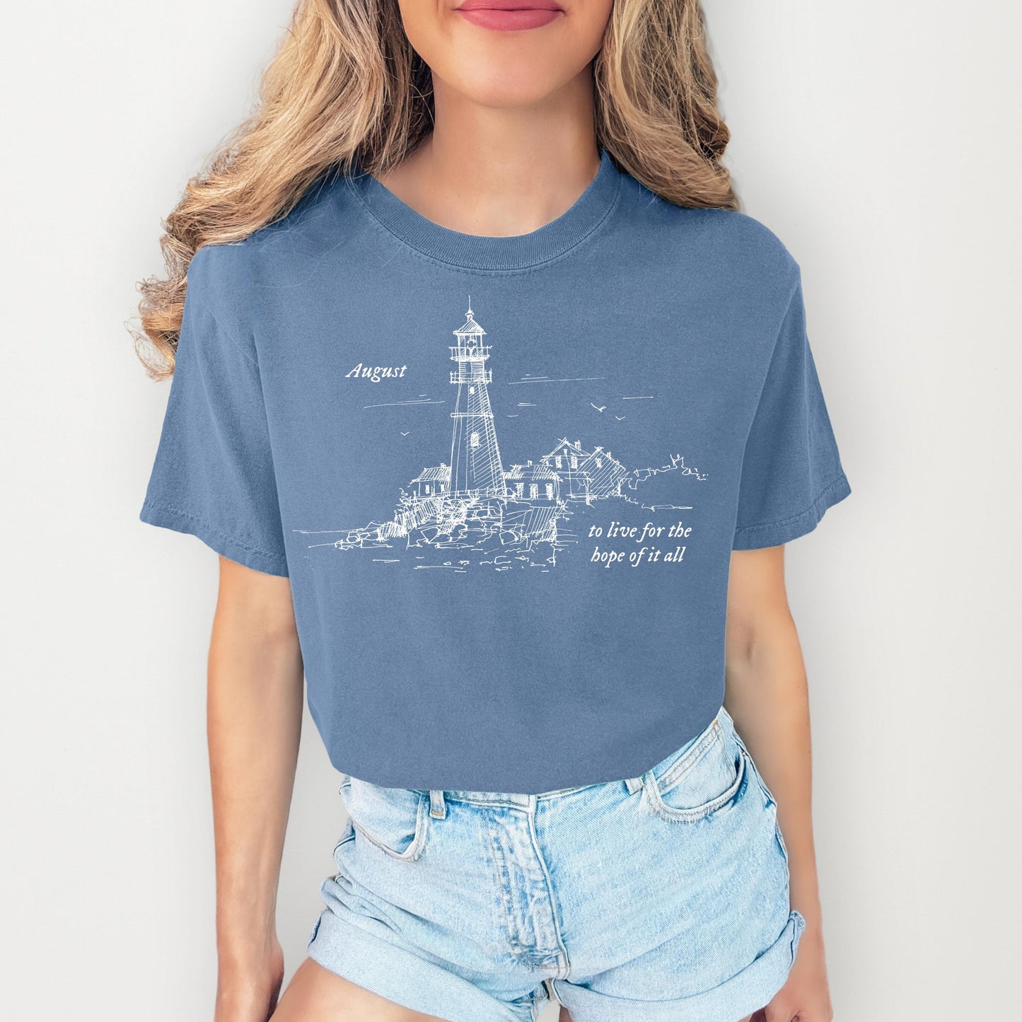 Person wearing a blue t-shirt with a lighthouse design and text.