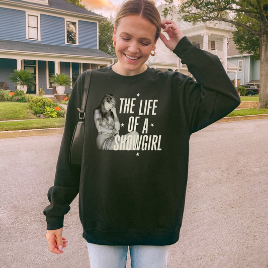 Woman wearing a black sweatshirt with a graphic and text, standing in a residential area.