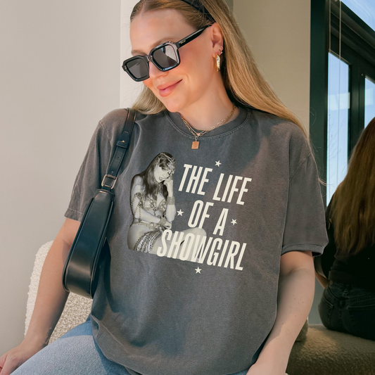 Woman wearing a t-shirt with 'Showgirl' text and graphic.