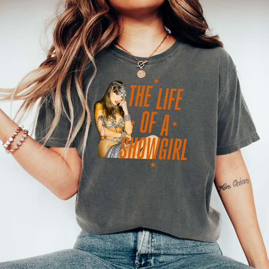Person wearing a t-shirt with a graphic and text 'Showgirl' on a plain background