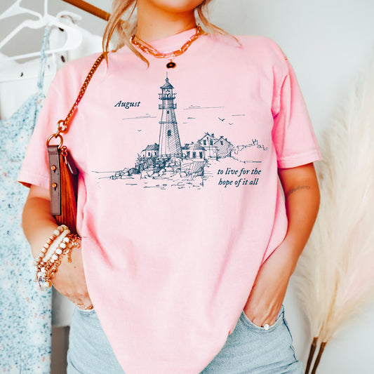 Person wearing a pink t-shirt with a lighthouse design and text.